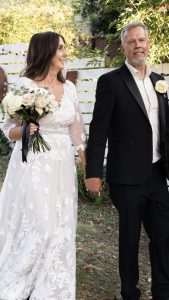 Real Bride Lisa wearing a blush wedding dress with sleeves